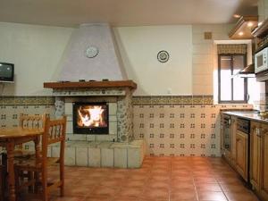 cocina con chimenea en el medio de una habitación en Casa Rural Los Roblones, en Rabanera del Pinar