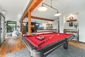 a pool table in a living room with a red pool table at Retro Razorback-Pickleball-Golf-Spa-UofA in Fayetteville