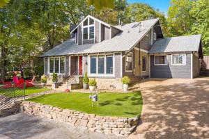 a house with a yard with a stone wall at Retro Razorback-Pickleball-Golf-Spa-UofA in Fayetteville