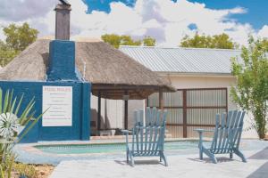 zwei blaue Stühle vor einem Pavillon in der Unterkunft Kate's Nest Guesthouse in Windhoek