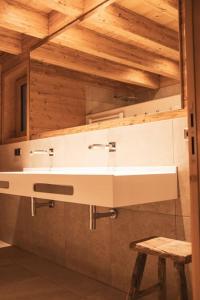 baño con lavabo blanco y taburete en Antons Exklusives Landgut en Oberstaufen