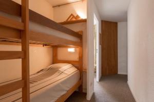 - une chambre avec 2 lits superposés et un couloir dans l'établissement Le 3300 - 20 - Appart expo sud - 6 pers, à Les Deux Alpes