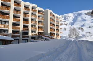 un bâtiment dans la neige avec un tas de neige dans l'établissement Le 3300 - 20 - Appart expo sud - 6 pers, à Les Deux Alpes