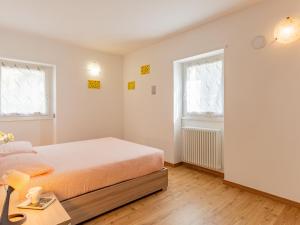 um quarto branco com uma cama e 2 janelas em Apartment Casa Rosalba by Interhome em Riva