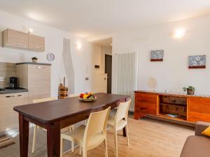 uma cozinha e sala de jantar com uma mesa de madeira e cadeiras em Apartment Casa Rosalba by Interhome em Riva