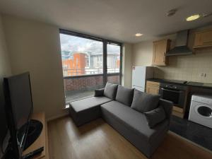 a living room with a couch and a large window at Immaculate 2-Bed Duplex Apartment in Leeds in Leeds