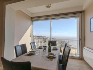 ein Esszimmer mit einem Tisch und Stühlen sowie einem großen Fenster in der Unterkunft Apartment Saint Sordelin by Interhome in Strand Pontaillac