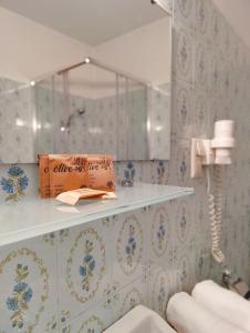 une salle de bains avec du papier peint bleu et blanc et une étagère. dans l'établissement Lorenzhof by JULKA - self checkin, à Ledenitzen
