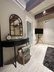 - un bureau avec un miroir et une chaise dans la chambre dans l'établissement Ta' Pinu Spa Suite - Luxury Heritage Living, à Żebbuġ
