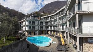 um hotel com piscina em frente a um edifício em Residence Alessandra em Domaso