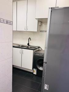 a kitchen with a sink and a washing machine at Luxury Self-Catering Apartment in Johannesburg