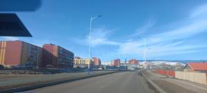 a street with street lights on the side of a road at Nomad Airport Hostel in Ulaanbaatar