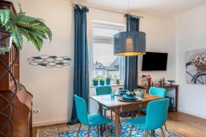 a dining room with a table and blue chairs at Wohnung Spa in Baden-Baden