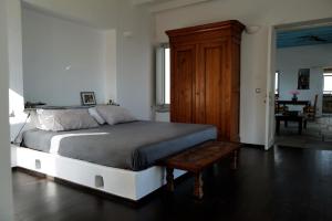 a bedroom with a large bed and a wooden cabinet at VillainPatmos in Patmos