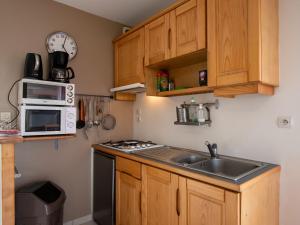 a kitchen with a sink and a microwave at Holiday Home de Beniguet by Interhome in Saint-Pabu