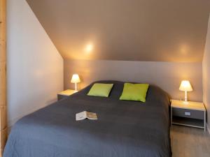 a bedroom with a bed with two green pillows at Holiday Home de Beniguet by Interhome in Saint-Pabu +19 photos