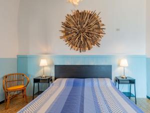 um quarto com uma cama grande com duas mesas e uma cadeira em Apartment Gaetano - SRZ310 by Interhome em Rezzonico