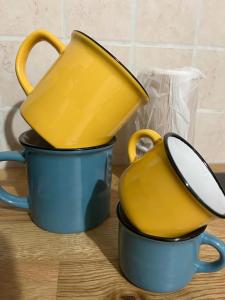 ローマにあるVacanze Deafの茶碗2杯の上に置かれた黄色と青の茶鍋