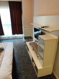 a hotel room with a dresser with a tv in it at Mavikapı Suit in Istanbul