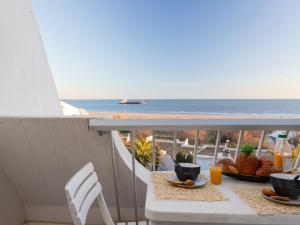 a table with food and a view of the ocean at Apartment La Calypso-6 by Interhome in La Grande-Motte