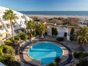 an overhead view of a swimming pool and the beach at Apartment La Calypso-6 by Interhome in La Grande-Motte