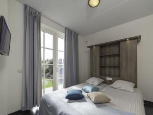 ColijnsplaatにあるHoliday Home Ganuenta by Interhomeのベッドルーム1室(大型ベッド1台、枕2つ付)