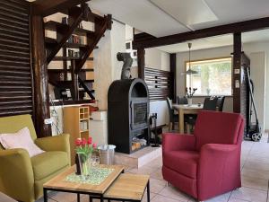 a living room with colorful chairs and a wood stove at Holiday Home Sorgenfrei by Interhome in Frankenau