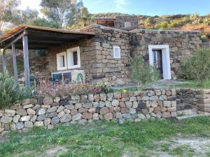 a stone house behind a stone wall at Dammusino: mini-appartamento in Pantelleria
