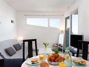 a living room with a table with food on it at Apartment La Tour Fenestrelle by Interhome in La Grande Motte