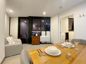a dining room with a table and a living room at Cosy 1B1B Apartment in South Bank in Melbourne