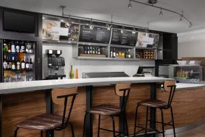 a bar with three stools and a counter with drinks at Courtyard by Marriott Orlando East/UCF Area in Orlando