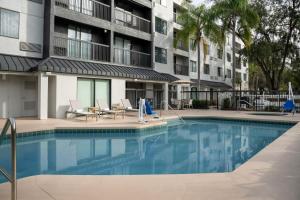einem Pool vor einem Apartmentgebäude in der Unterkunft Courtyard by Marriott Orlando East/UCF Area in Orlando