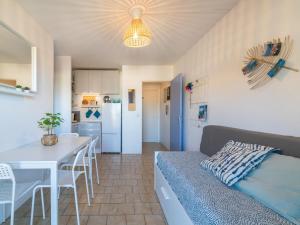 Una sala de estar y una cocina con un sofá y una mesa. en Apartment Saint James-12 by Interhome, en Le Lavandou
