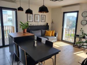 ein Wohnzimmer mit einem Tisch und einem Sofa in der Unterkunft Appartement Vélizy-Villacoublay in Vélizy-Villacoublay