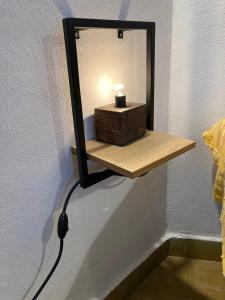 a mirror on a wall with a wooden shelf at Dammusino: mini-appartamento in Pantelleria
