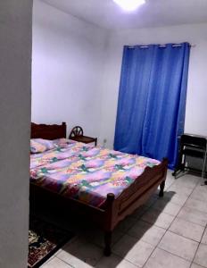um quarto com uma cama com uma cortina azul em La villa chez Ingrid em Antsiakambony