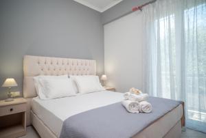 a white bedroom with a large bed with towels on it at Famozo Hill Private Villa in Káto Yerakaríon