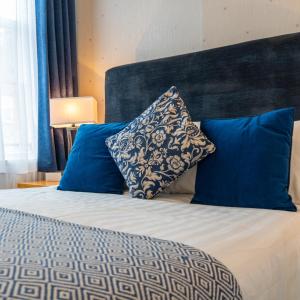 a bedroom with a bed with blue pillows at Eccles Townhouse in Dublin