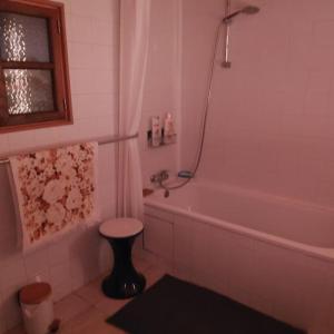 a bathroom with a tub and a toilet and a stool at Maison Cosy et Conviviale, Le B7 in Besset