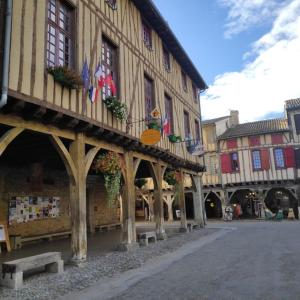 a building with flags on the side of a street at Maison Cosy et Conviviale, Le B7 in Besset
