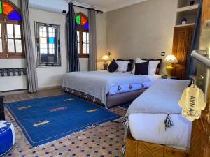 a bedroom with two beds and stained glass windows at Riad Tafilag in Taroudant