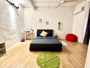een slaapkamer met een bed en een groen tapijt bij Cozy 10 Entire House 4 Bedroom At Alma Bukit Mertajam in Bukit Mertajam