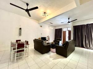 sala de estar con sofás, mesa y ventilador de techo en Cozy 10 Entire House 4 Bedroom At Alma Bukit Mertajam en Bukit Mertajam
