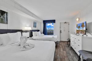 a hotel room with two beds and a window at Hosteeva Boardwalk Ocean-front Condo in Myrtle Beach