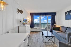 a living room with a couch and a tv at Hosteeva Boardwalk Ocean-front Condo in Myrtle Beach