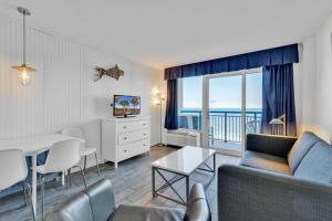 a living room with a couch and a table at Hosteeva Boardwalk Ocean-front Condo in Myrtle Beach
