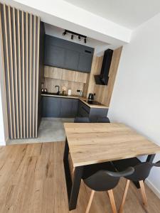 eine Küche und ein Esszimmer mit einem Holztisch in der Unterkunft Apart Family Lębork in Lębork + 9 Fotos