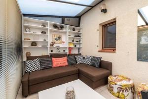 a living room with a brown couch and shelves at Between sea and Garrigues! in Vic-la-Gardiole