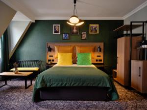 Abbey Hotel Bath, a Tribute Portfolio Hotel في باث: غرفة نوم بسرير بجدران خضراء ومخدات صفراء