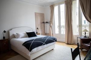 a bedroom with a bed and a large window at 4 bedroom Luxury Eiffel Tower Apartment in Paris